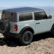 A 2023 Ford Bronco two-door in cactus gray is parked on a mountain.